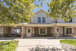 Front of property, featuring stone siding, stucco siding, and porch