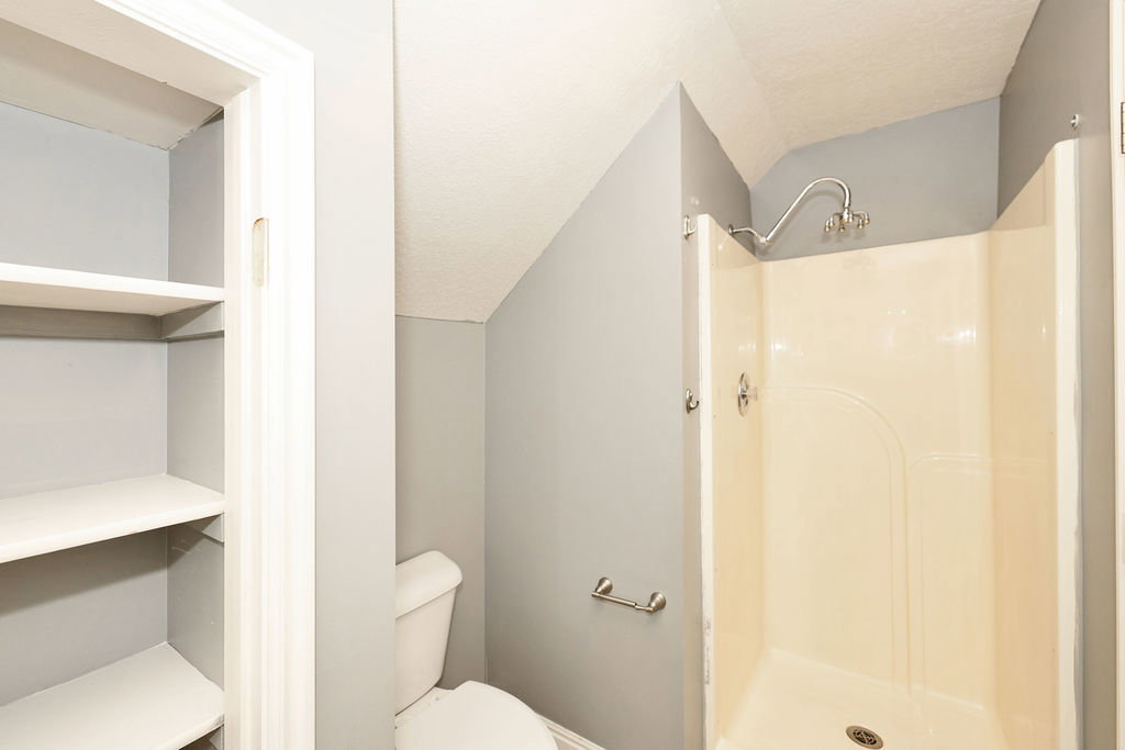 Full bathroom featuring toilet and a stall shower