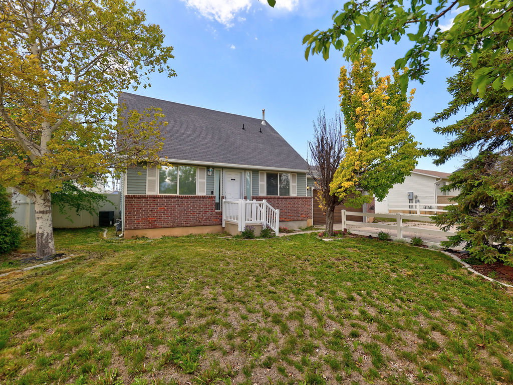 Back of property with brick siding and a shingled roof