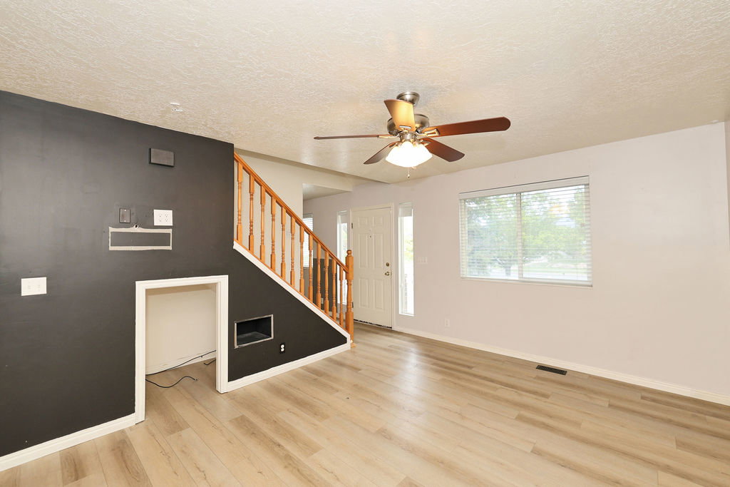 Entryway with ceiling fan, light wood finished floors, and a textured ceiling