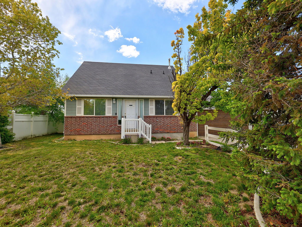 View of front of property featuring brick siding and roof with shingles