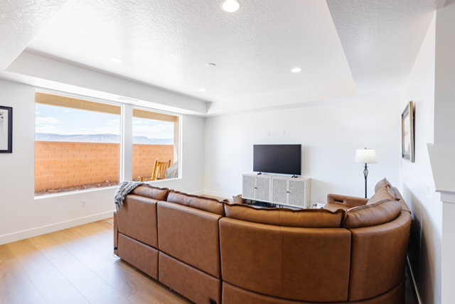 Bright living area featuring wood-finish flooring, recessed lighting, and large windows with integrated blinds