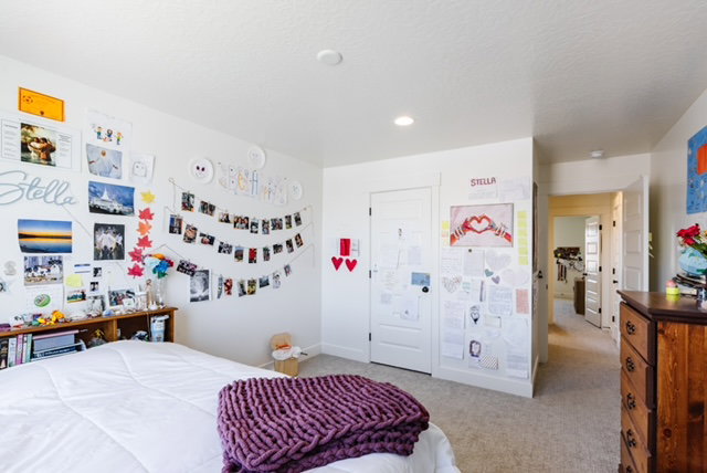 Carpeted room with a built-in headboard shelving unit and white interior doors