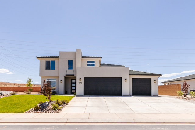 Contemporary stucco exterior featuring a two-story design and a flat roofline