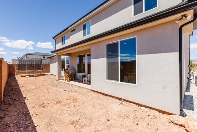 Rear exterior featuring a covered patio, stucco siding, and multiple windows
