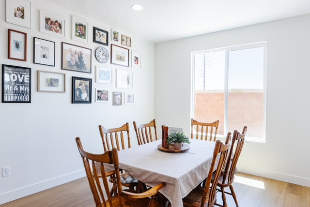 Bright dining space featuring a large window, recessed lighting, white baseboards, and wood-finish flooring