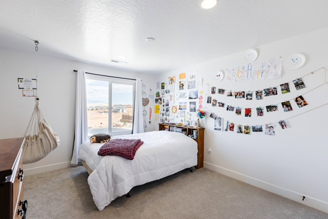 Carpeted interior space featuring a large window with white trim, recessed lighting, and a neutral color palette