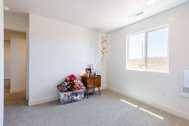 Room featuring a window with a distant landscape, light-toned carpeting, white walls, and white baseboards