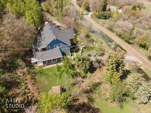 View of subject property featuring a tree filled landscape