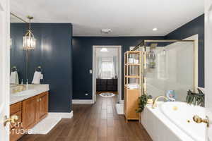 Full bathroom with vanity, wood tiled floors, a jetted tub, and a stall shower
