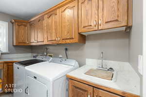 Laundry room featuring washing machine and clothes dryer and cabinet space