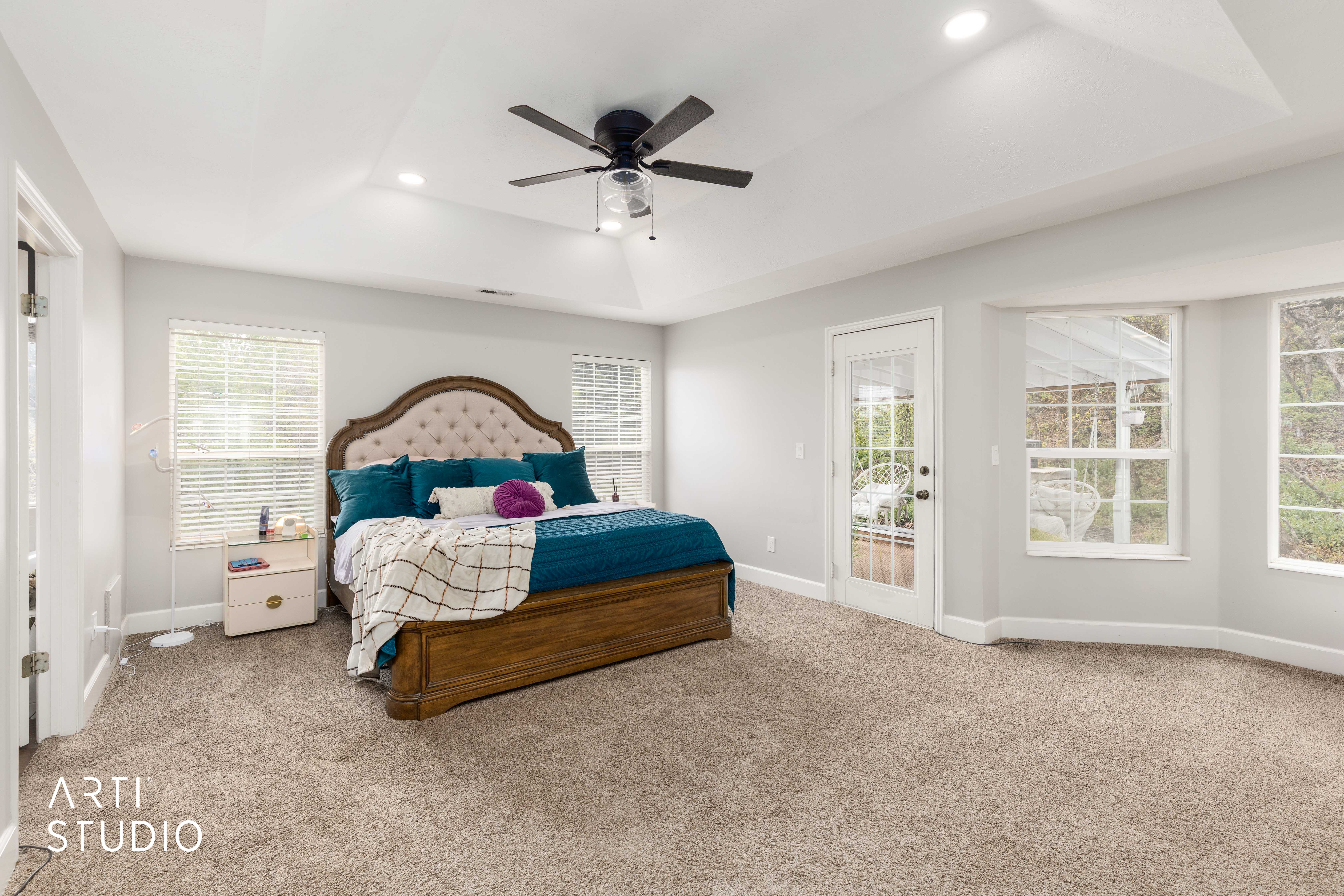 Bedroom featuring access to outside, a tray ceiling, light colored carpet, ceiling fan, and recessed lighting