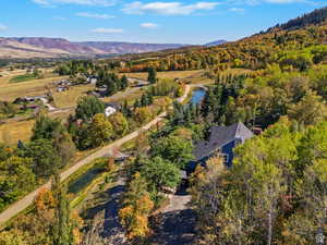 Aerial perspective showcasing a property surrounded by mature trees with autumnal foliage