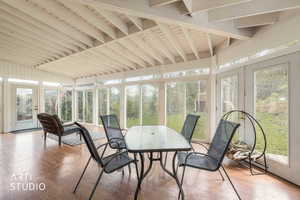 Sunroom with french doors, wood finished floors, and vaulted ceiling with beams
