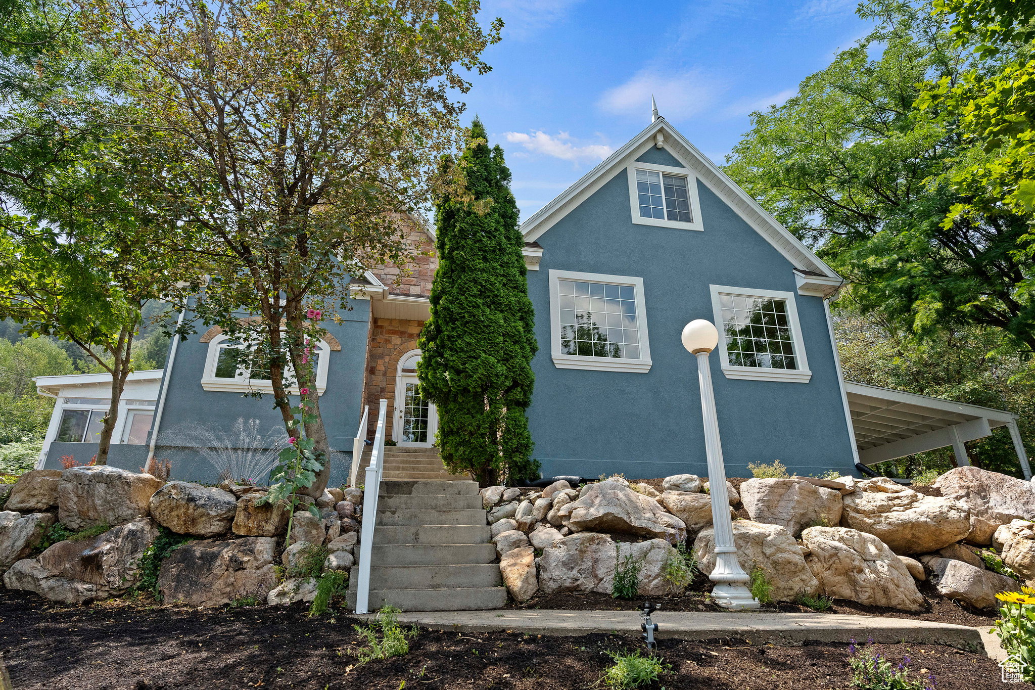 Two-story residence featuring a blue exterior and a stone facade accent