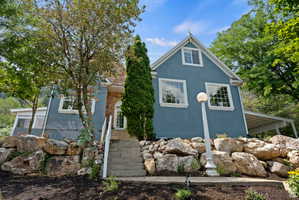 Two-story residence featuring a blue exterior and a stone facade accent
