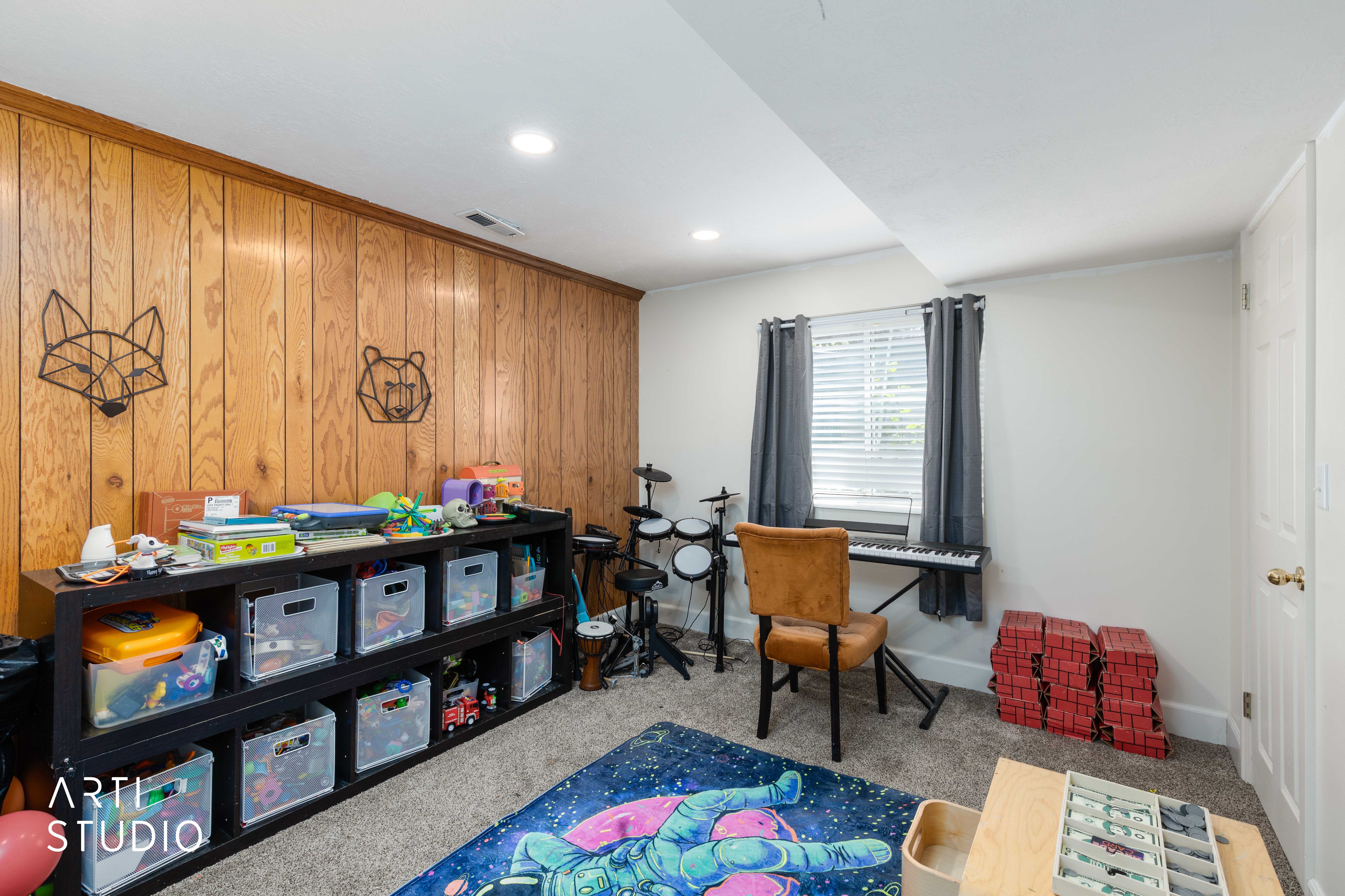 Carpeted home office featuring wooden walls and baseboards