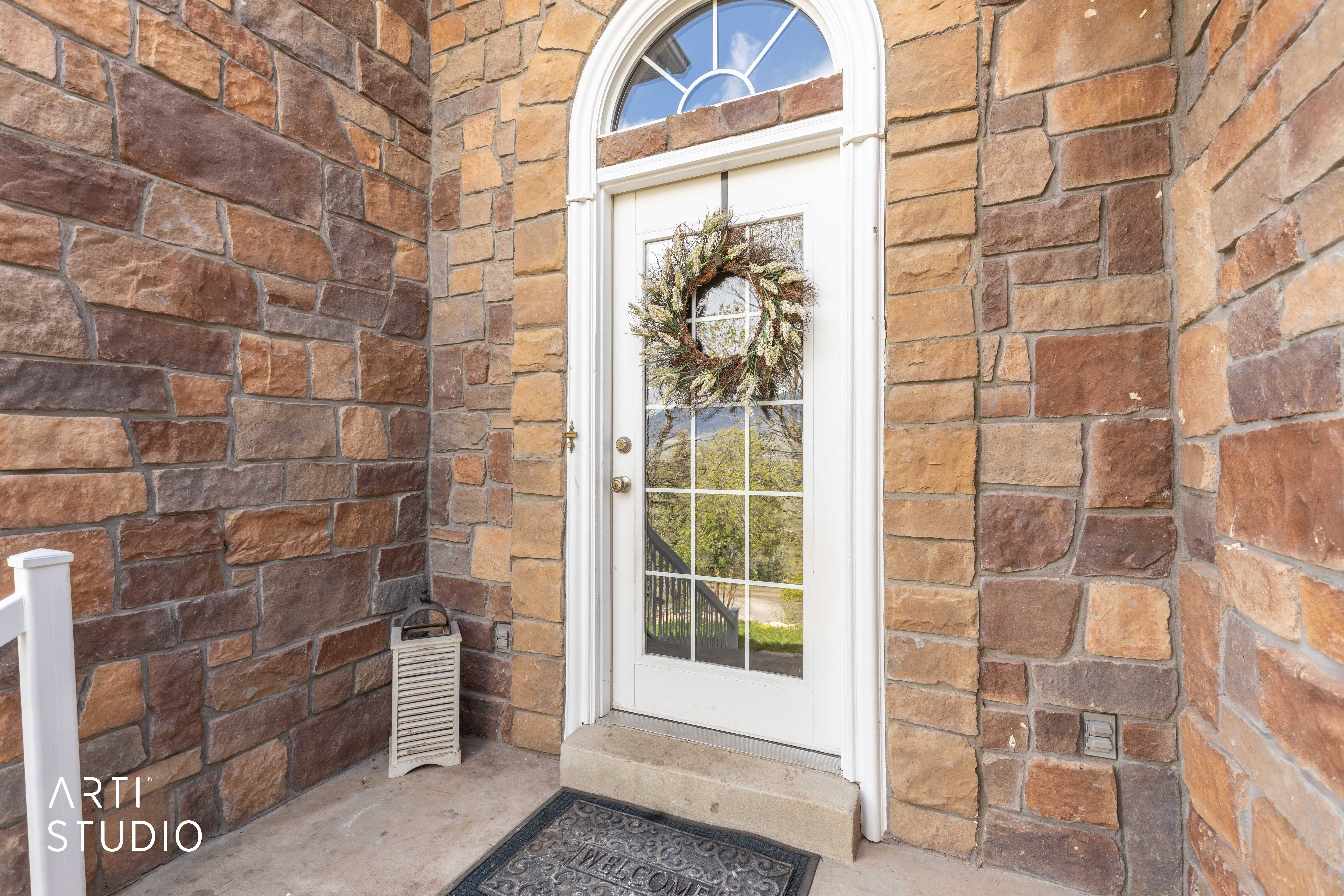 Property entrance featuring brick siding and stone siding