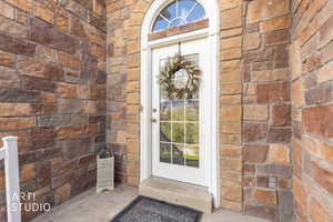 Property entrance featuring brick siding and stone siding