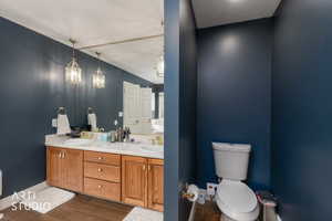 Bathroom with double vanity, wood tiled floors, and lofted ceiling