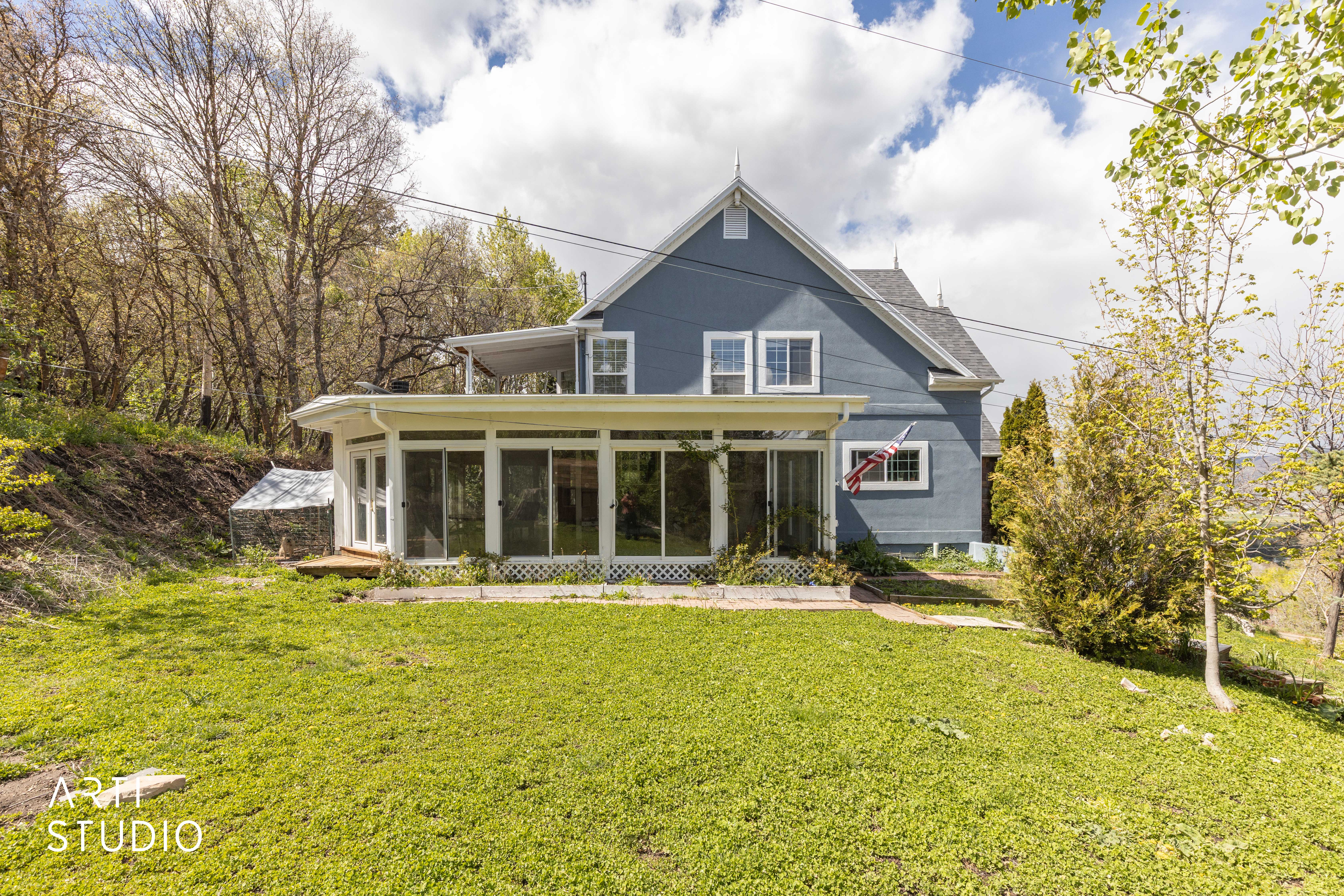 Rear view of house featuring a sunroom and a lawn