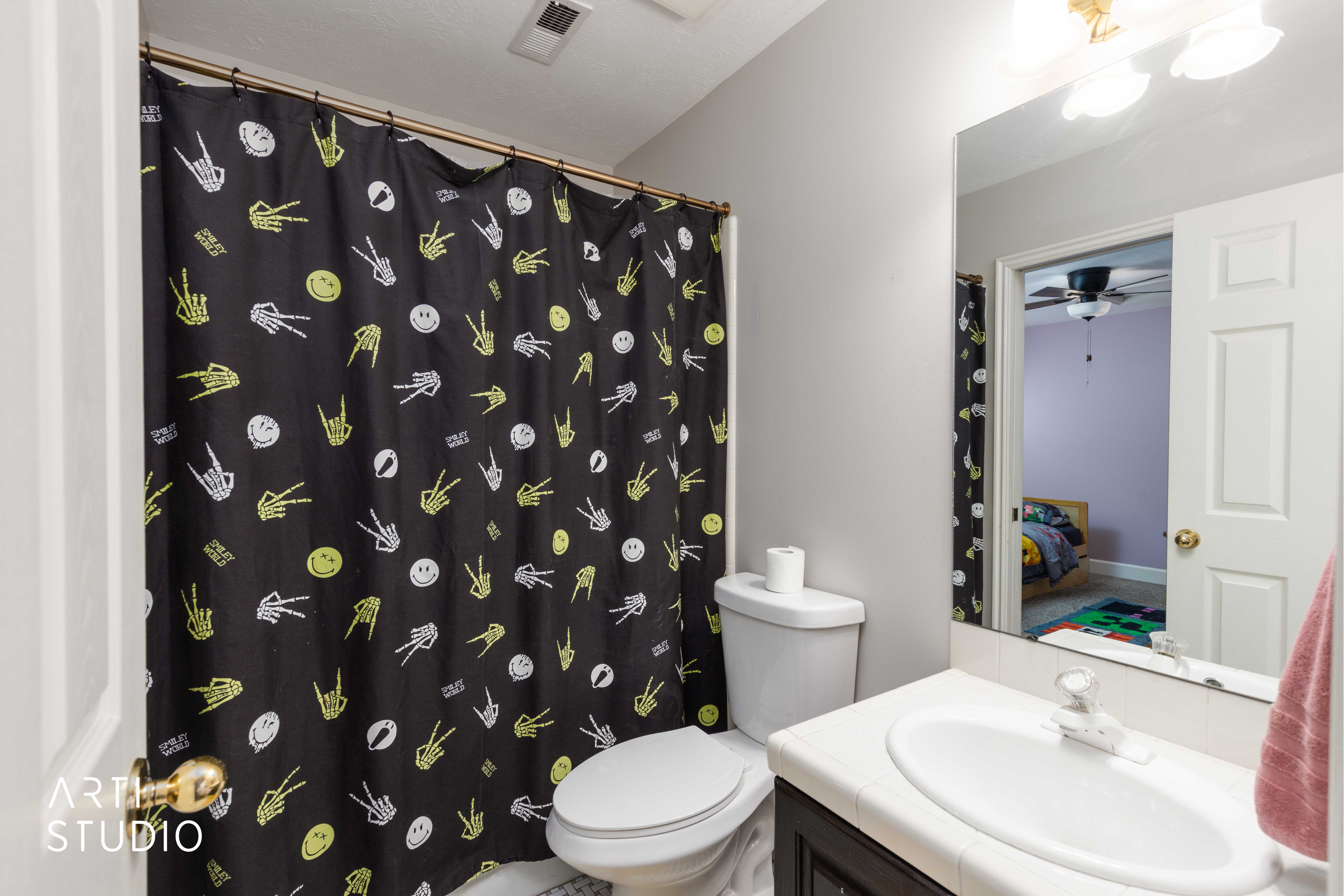 Bathroom with vanity, curtained shower, ceiling fan, and ensuite bathroom