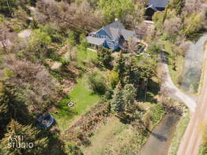 Aerial view of property and surrounding area with a tree filled landscape