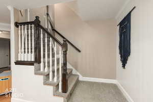 Stairs featuring carpet and crown molding