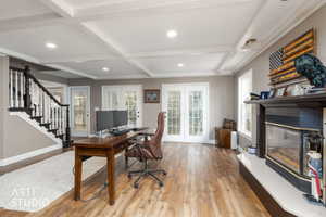 Home office with coffered ceiling, a glass covered fireplace, french doors, light wood-style flooring, and recessed lighting