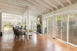 Sunroom featuring vaulted ceiling with beams