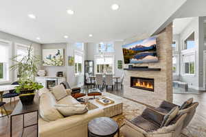 Living area featuring recessed lighting, wood floors, and a fireplace