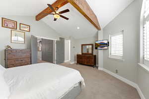Primary Bedroom with beamed ceiling, plantation shutters, light colored carpet, and a ceiling fan