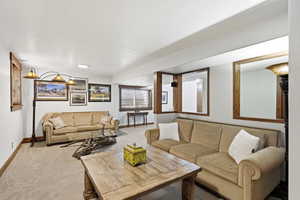 Carpeted living area featuring baseboards