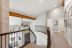 Corridor with vaulted ceiling, light carpet, healthy amount of natural light, an upstairs landing, and recessed lighting