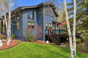 Back of property featuring a yard and a wooden deck