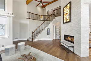 Living area featuring a stone fireplace, wood floors