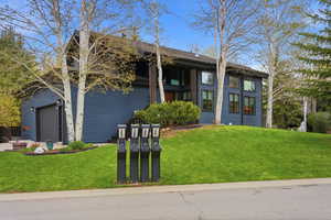 Mid-century modern home with a front lawn and an attached garage