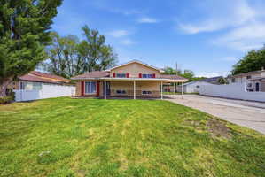Back of property with covered porch and brick siding