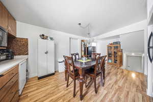 Dining room with light wood-type flooring and vaulted ceiling