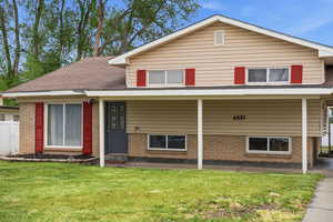 View of front of house with brick siding and a porch