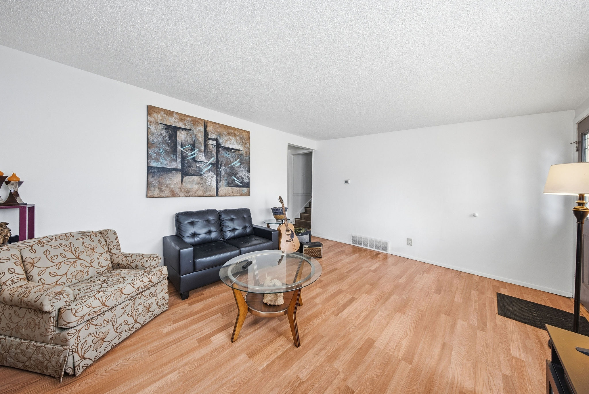 Living area with light wood-style floors and a textured ceiling