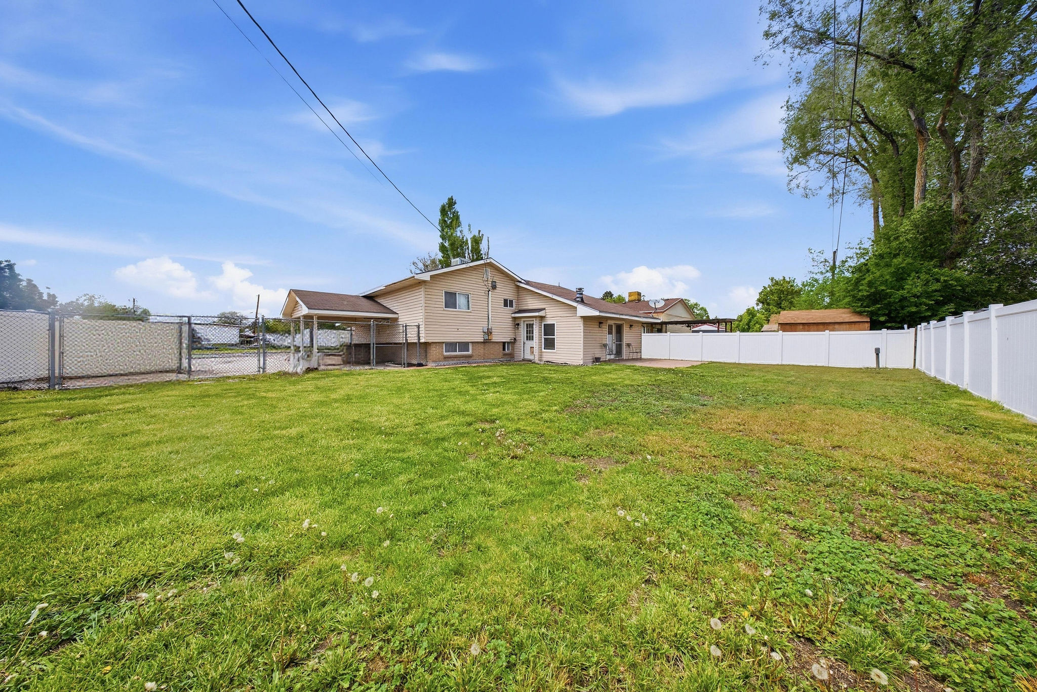 Rear view of property featuring a gate, a fenced backyard, and a sunroom