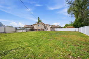 Rear view of property featuring a gate, a fenced backyard, and a sunroom