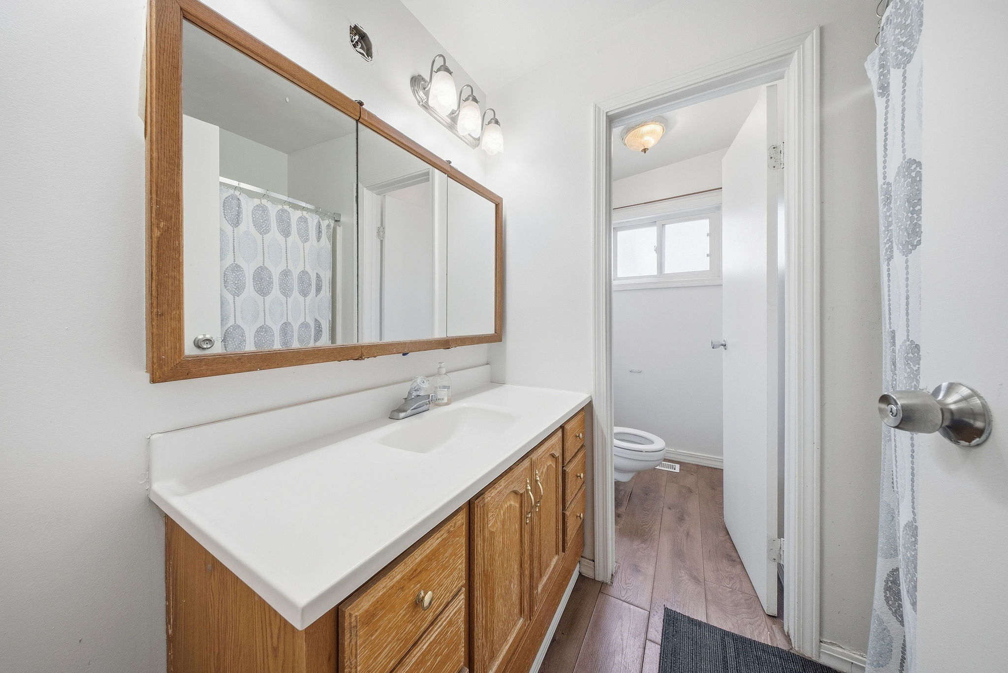 Full bathroom with vanity, a shower with curtain, and light wood finished floors