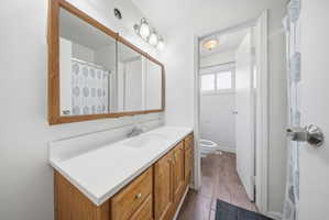 Full bathroom with vanity, a shower with curtain, and light wood finished floors