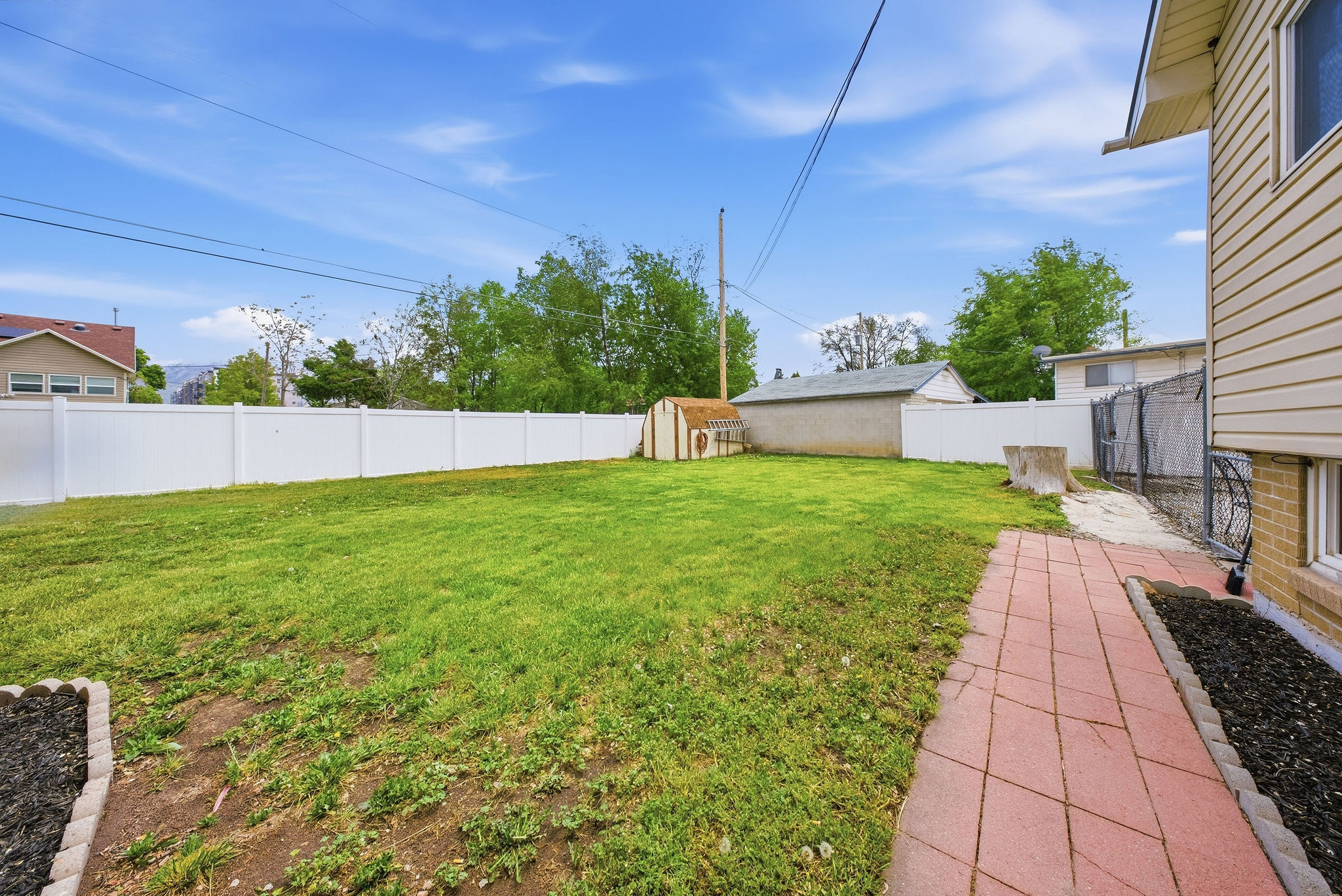Fenced backyard with a storage shed
