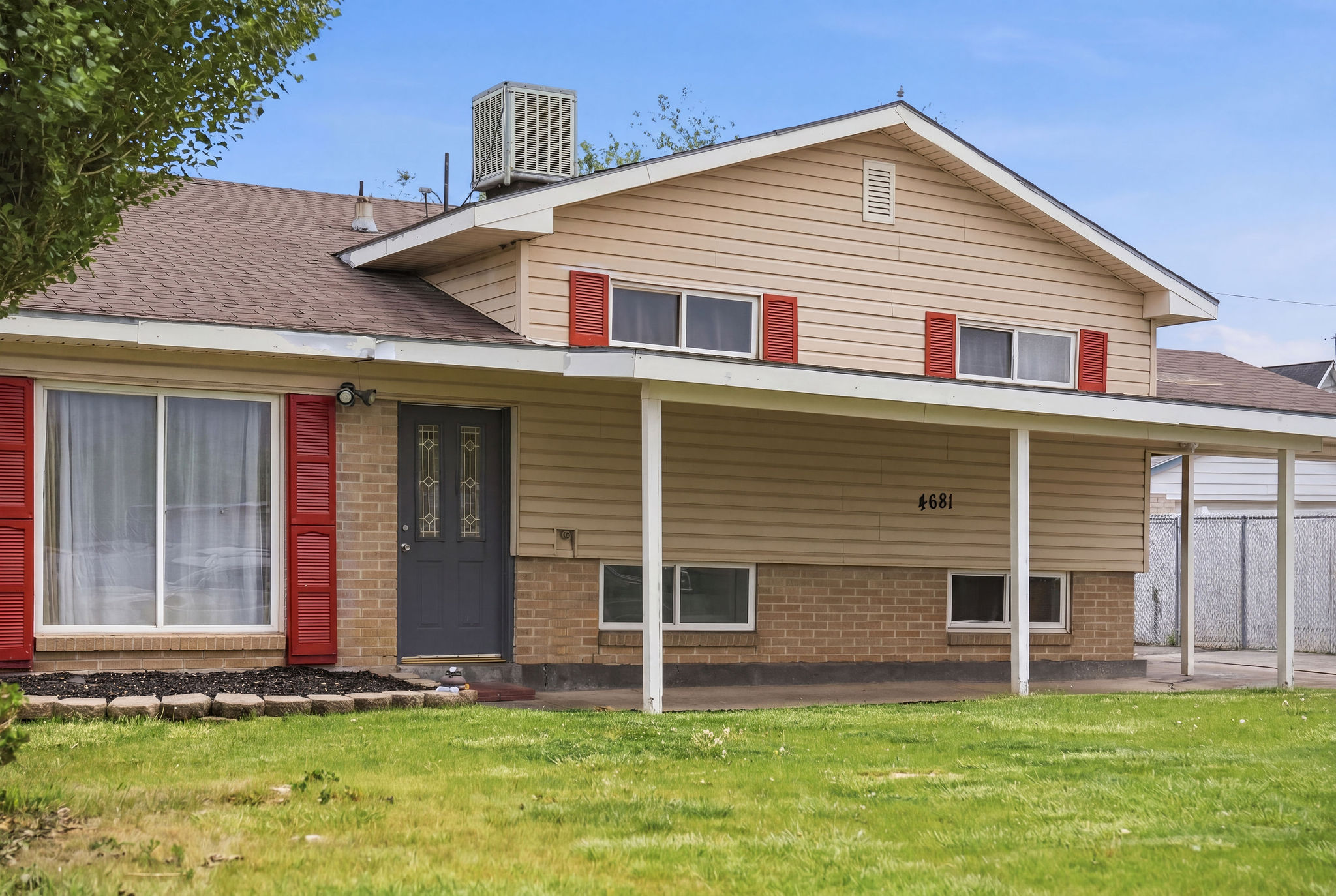 Rear view of house with a yard, brick siding, a porch, and a shingled roof
