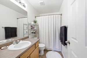 Full bathroom with vanity, a shower with curtain, and a textured ceiling