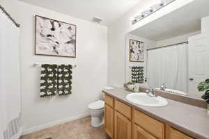 Bathroom featuring curtained shower, vanity, and a textured ceiling