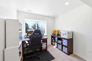 Home office with light colored carpet and baseboards